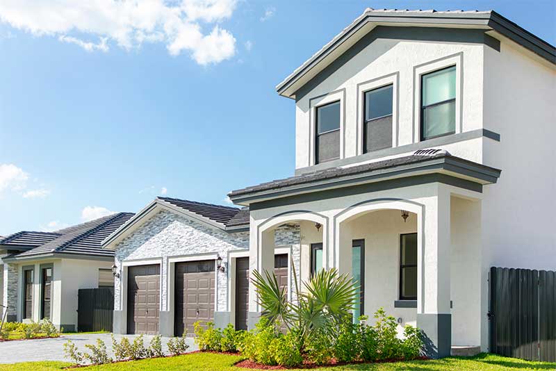 Front door space with driveway and lawn.