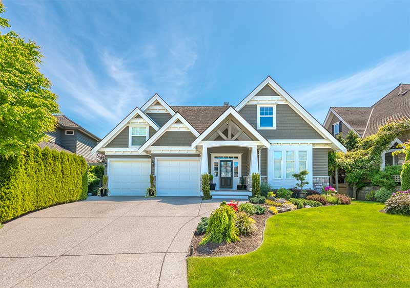 Front of House with driveway and landscaping.