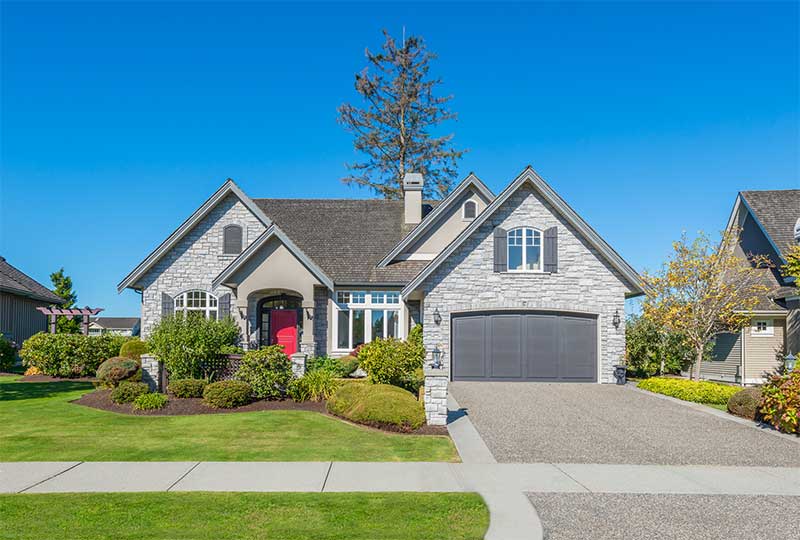 Front of House with driveway and landscaping.