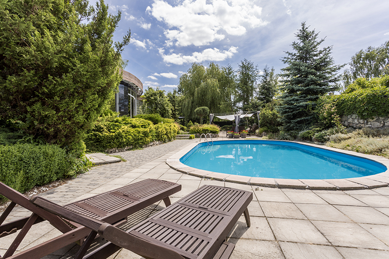 Backyard pool with lounge chairs.