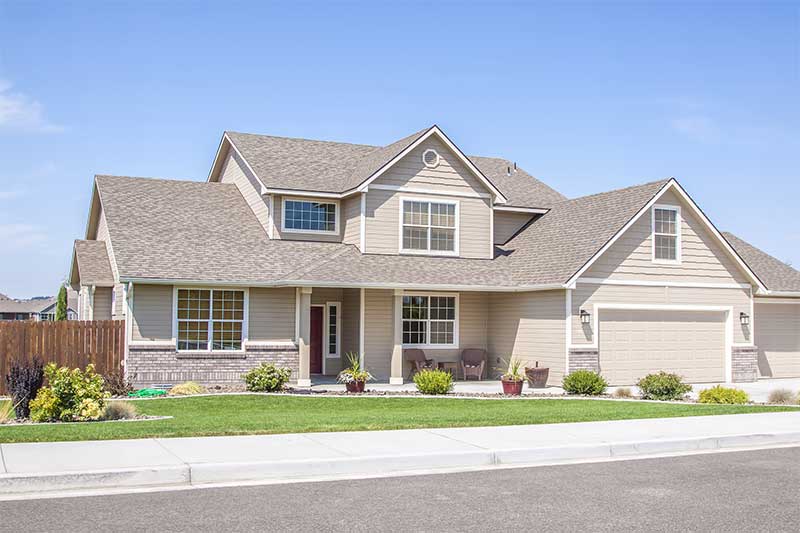 Front of house with drive way and panel windows.