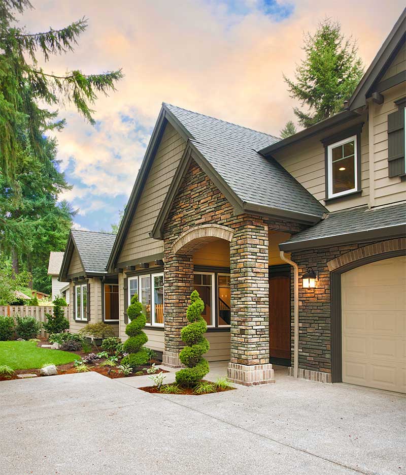 Front door space with driveway and lawn.