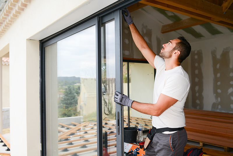 Contractor installing sliding glass door window.