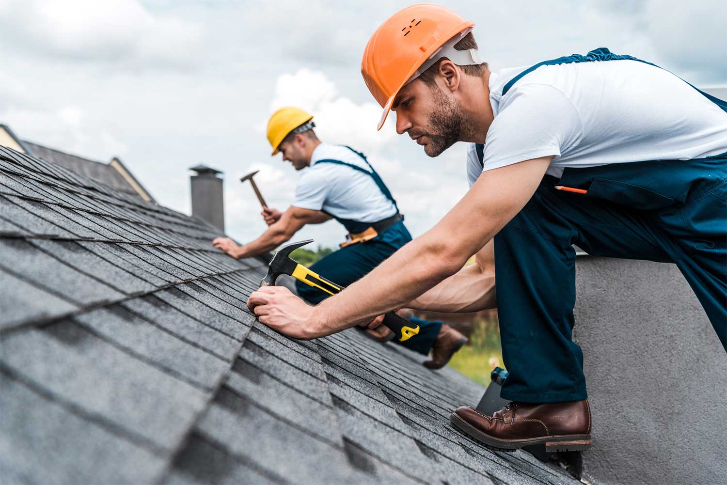 Roofing contractors securing asphalt shingles.