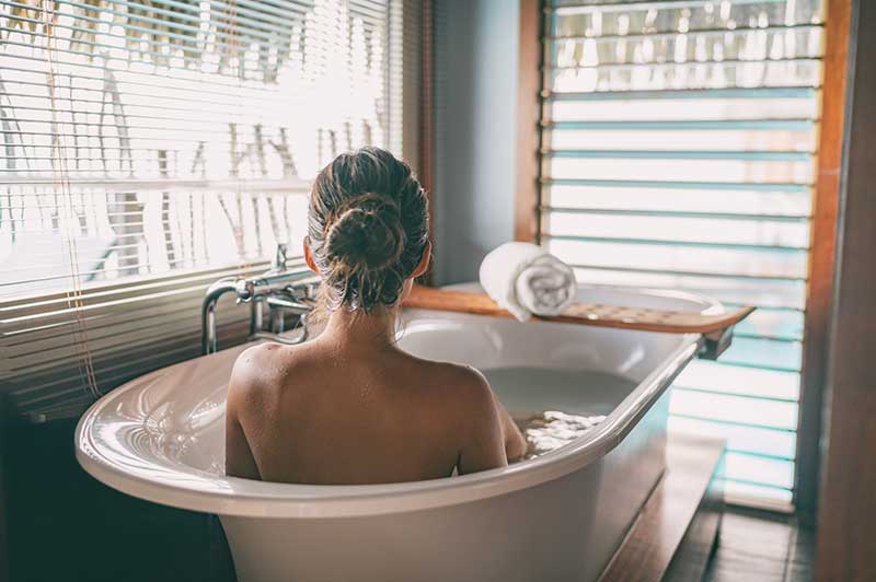 Women in bathtub soaking.